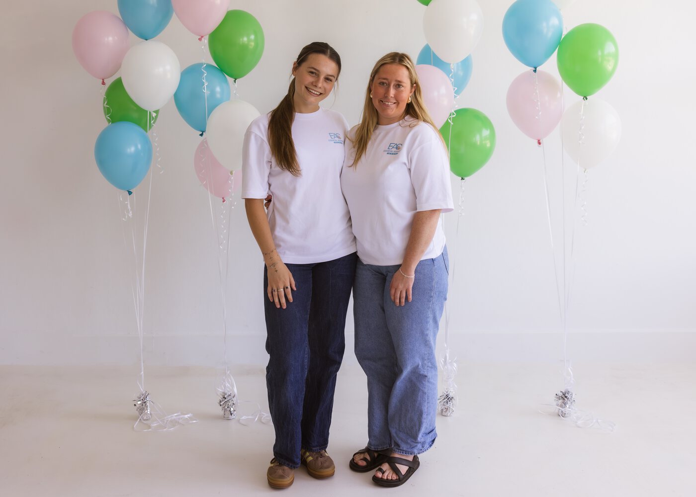 Two Essential Assistant Care team members standing together outdoors