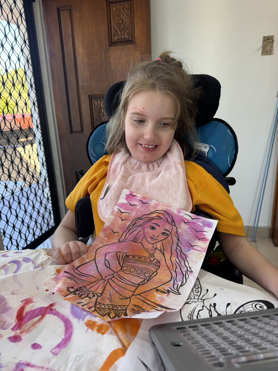 A client showing a colourful artwork during a creative activity