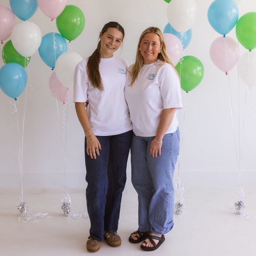 Two Essential Assistant Care team members standing together at a studio event
