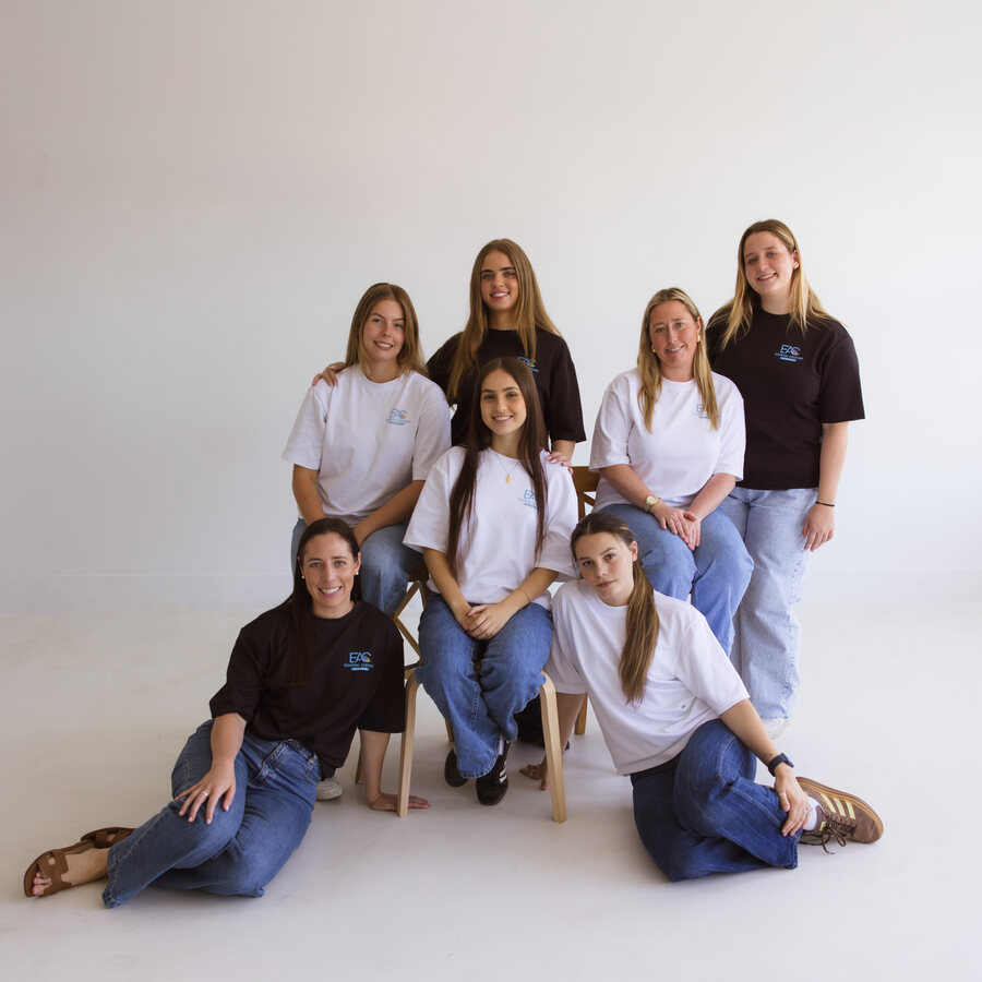 Essential Assistant Care team gathered in a relaxed studio group