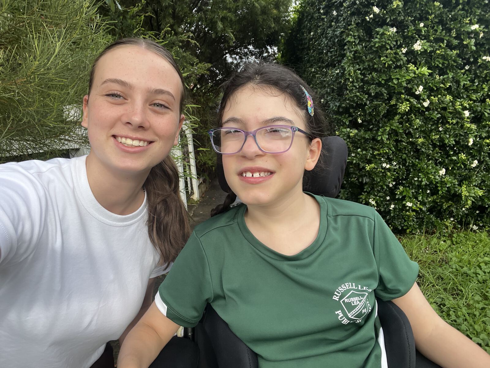 Participant and support worker smiling together outdoors