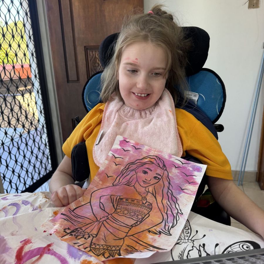 Client smiling while showing a colourful art activity