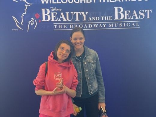 A client and support worker at a theatre outing